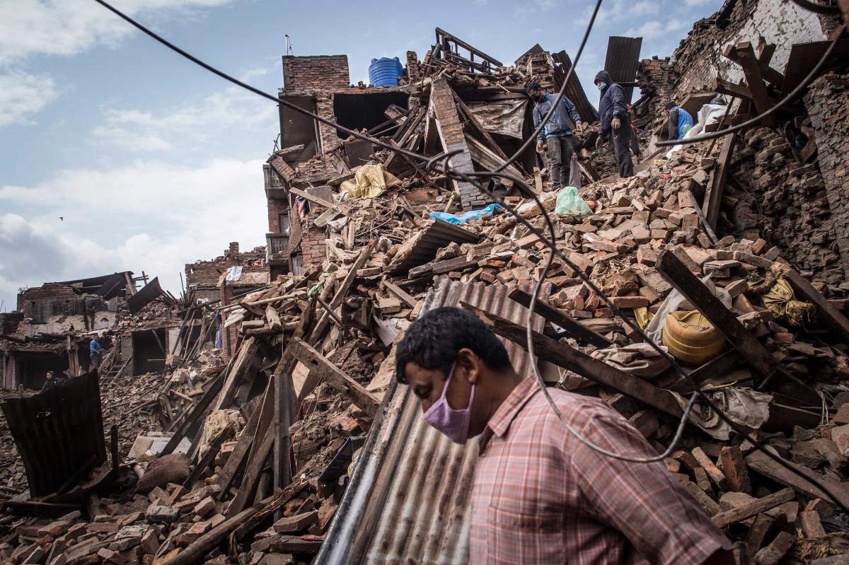 BHAKTAPUR, NEPAL - APRIL 29: Nepalese victims of the earthquake search for their belongings among debris of their homes on April 29, 2015 in Bhaktapur, Nepal. A major 7.8 earthquake hit Kathmandu mid-day on Saturday, and was followed by multiple aftershocks that triggered avalanches on Mt. Everest that buried mountain climbers in their base camps. Many houses, buildings and temples in the capital were destroyed during the earthquake, leaving over 4600 dead and many more trapped under the debris as emergency rescue workers attempt to clear debris and find survivors. Regular aftershocks have hampered recovery missions as locals, officials and aid workers attempt to recover bodies from the rubble. (Photo by David Ramos/Getty Images)