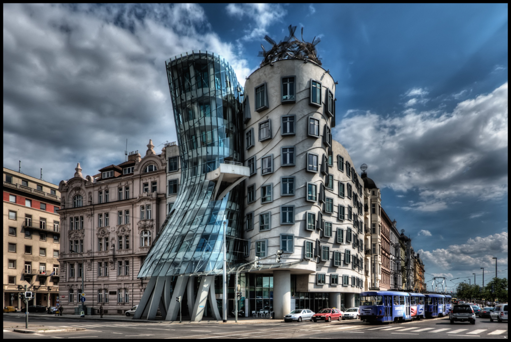 I have about 500 shots of the Dancing House in Prague from every possible angle, portrait and landscape. They've been sitting on my disk for almost 2 years. I didn't know how to process them as the light was not great and an early attempt using Photomatix was a disaster. ISO 100, 14mm, f6.3, (1/1600, 1/400, 1/100 secs). I chose the f-stop so that I would get fast enough speed for the moving cars. Blended and tonmeppaed in Photomatix using Details Enhancer. Reduced noise in Imagenomics Noiseware. Carefully straightened the vertilcals using the Lens Correction filter in PS as the whole point if the building is it's vertical lines. Used the Freaky Details technique to get lots of details on the windows, etc. Used Nik Viveza to reduce the white glow around the building that was left over from Photomatix processing (masking the clouds). Used 15% Nik Glamour Glow to reduce the harshness of the Photomatix and Freaky Details.