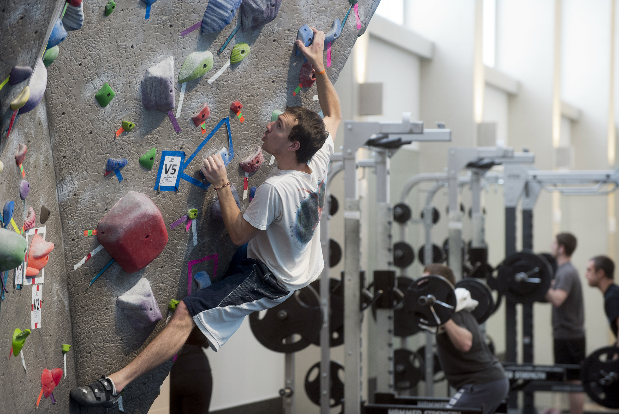 Garrett Quathamer, a junior in anthropology from Indianapolis, climbs the bouldering wall two to three times a week at the France A. Crdova Recreational Sports Center. Data collected by the center shows that students who visit the facility at least 16 times a month earned a GPA of 3.10 or higher. The correlation between grades and gym use also is shown with moderate users. (Purdue University photo/Mark Simons)